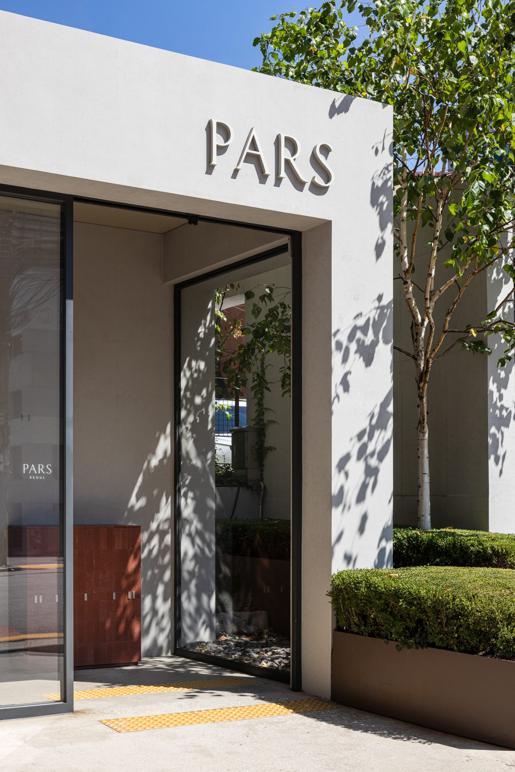 흰 파사드에 PARS 사인이 붙은 파르스 서울 사옥 입구